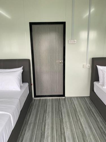 a room with two beds and a door at 1108 Pedas Village Resort in Pedas