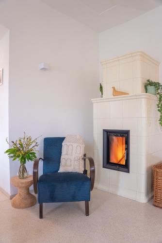 a blue chair in a living room with a fireplace at Zámek Načeradec in Načeradec