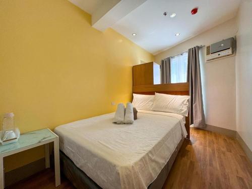 a bedroom with a bed in a room with a window at Almond Suites by Hiverooms in Cebu City