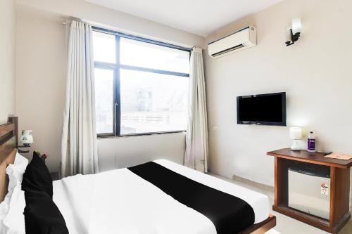 a bedroom with a bed and a large window at Townhouse Malviya Nagar Near Airport Formerly Royal Residency in Jaipur