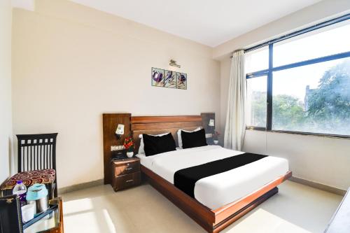 una camera da letto con un letto e una grande finestra di Super Townhouse Malviya Nagar Near Airport Formerly Royal Residency a Jaipur
