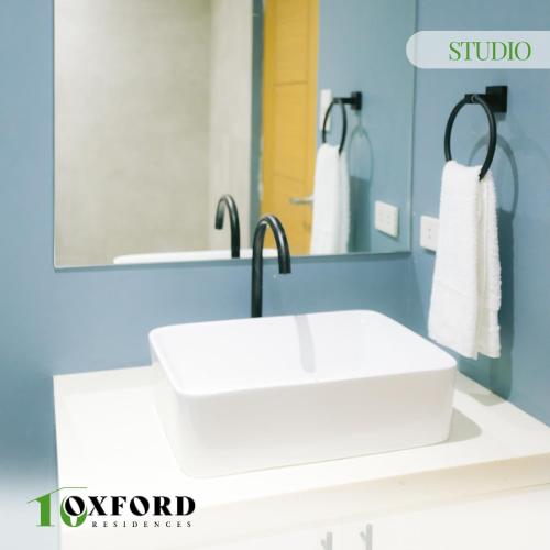 a bathroom with a white sink and a mirror at 10 Oxford Residences in Quezon City