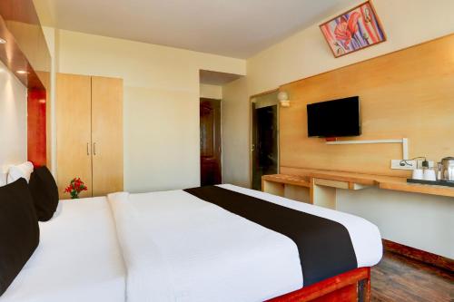 a hotel room with a bed and a tv at Townhouse Fateh Sagar Formerly Vatika Inn in Udaipur