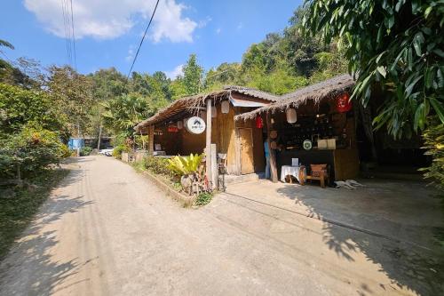 a dirt road in front of a small building at Mae Mae Home in Ban Tham