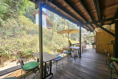 a wooden deck with tables and chairs and umbrellas at Mae Mae Home in Ban Tham