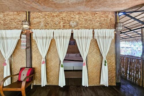 a bedroom with curtains and a bed on a balcony at Mae Mae Home in Ban Tham