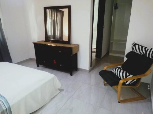 a bedroom with a bed and a dresser and a mirror at Cool Flat Cidade - Airport in Luanda