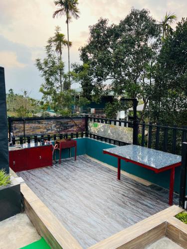a deck with a bench and a table on top at Tea vista holiday home in Kalpetta