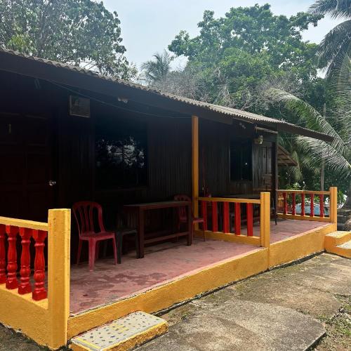 a house with a table and chairs on a porch at Johans Chalet in Tioman Island