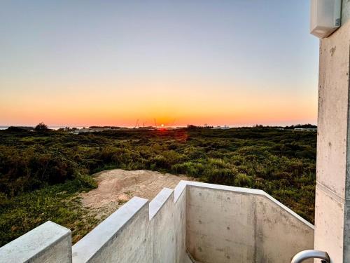 a sunset seen from the outside of a building at CondoYumangi in Onna