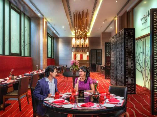 a man and woman sitting at a table in a restaurant at Welcomhotel by ITC Hotels, Richmond Road, Bengaluru in Bengaluru
