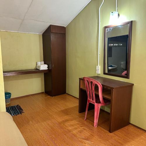 a desk with a pink chair in a room at Johans Chalet in Tioman Island