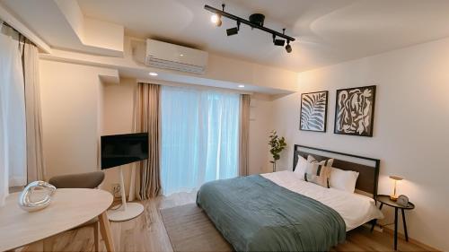 a bedroom with a bed and a table and a television at Dash Living Ryogoku in Tokyo