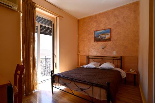 sypialnia z łóżkiem i dużym oknem w obiekcie Electra Hotel Piraeus w Pireusie