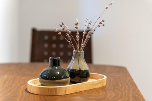 two vases sitting on a table with flowers in them at Apartments Bauer in Grafing