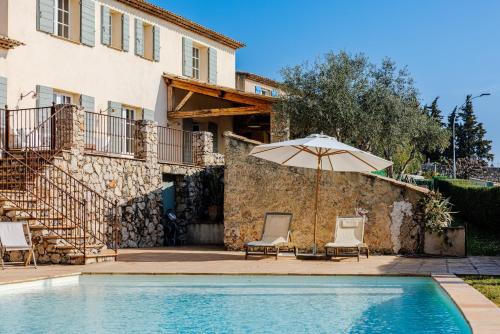 une villa avec une piscine et un parasol dans l'établissement Mas Gauda, à La Gaude