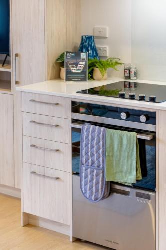 a kitchen with a stove with towels hanging from it at City Haven 1BR Near Ara Institute & CBD in Christchurch