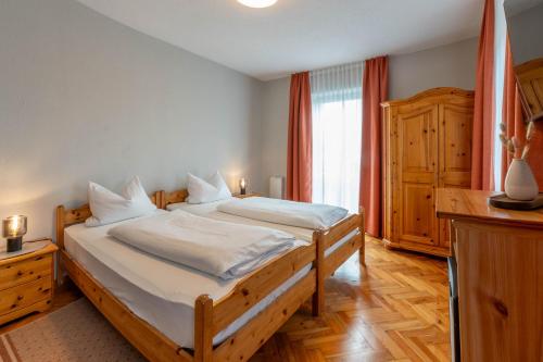 a bedroom with a large bed with white sheets at Apartments Bauer in Grafing