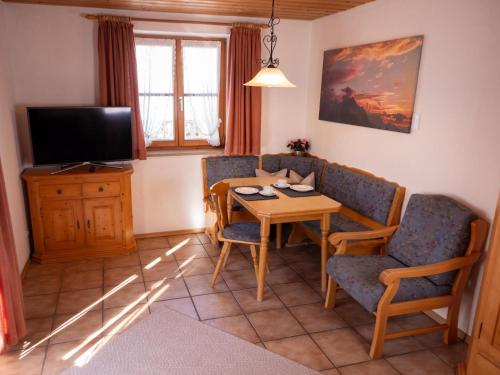 a living room with a table and chairs and a television at Haus Verena Mittenwald in Mittenwald