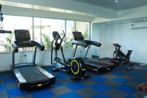 a gym with two treadmills and two elliptical machines at Tania President Inn in Shirdi
