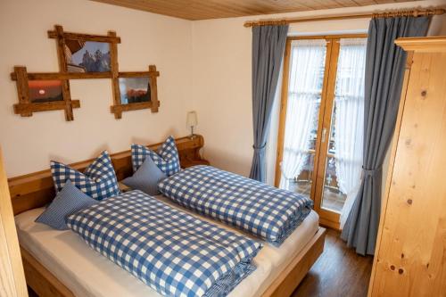 a bedroom with two beds with blue and white pillows at Haus Verena Mittenwald in Mittenwald