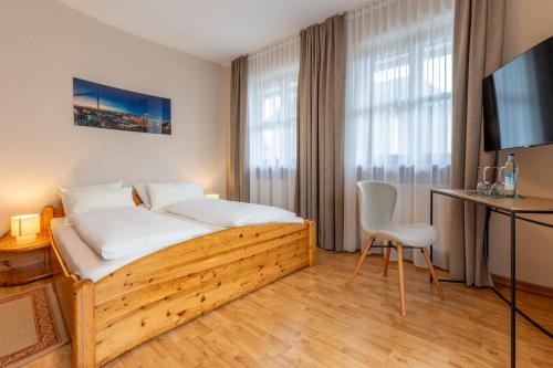 a bedroom with a bed and a table and a chair at Apartments Bauer in Grafing