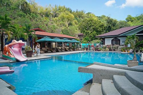 a swimming pool with a slide in a resort at Bella Vista Resort in Naguilian