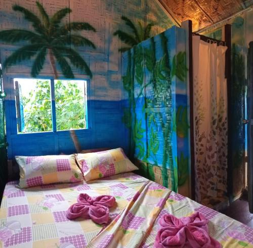 a bedroom with a bed with bows on it at Villa-Atlas Guest House in Malapascua Island