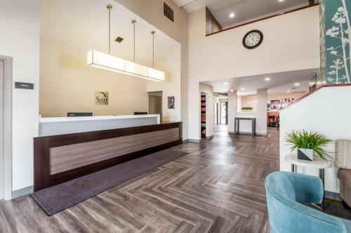 an office lobby with a reception counter and a clock at Sleep Inn & Suites Rehoboth Beach in Rehoboth Beach