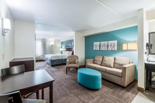 a living room with a couch and a bed at Sleep Inn & Suites Rehoboth Beach in Rehoboth Beach