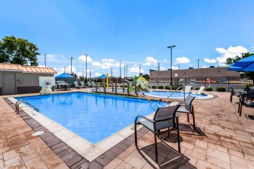 a large swimming pool with two chairs next to it at Sleep Inn & Suites Rehoboth Beach in Rehoboth Beach