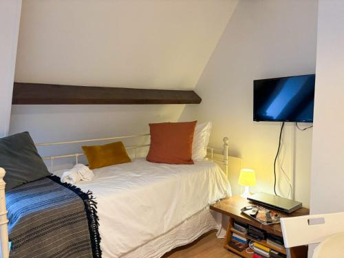a small bedroom with a bed and a tv at Charmant duplex au calme "La Tourelle" avec wifi in Rémalard en Perche
