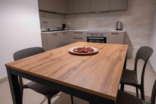 a kitchen with a wooden table with a plate of food on it at Central View Apartment in Cava deʼ Tirreni