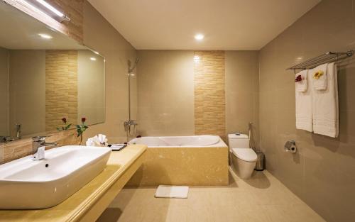 a bathroom with a tub and a sink and a toilet at Lam Giang Hotel in Vinh