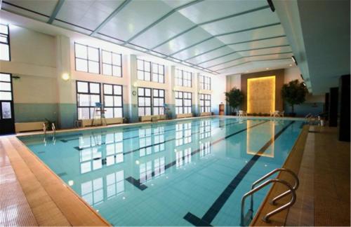 a large swimming pool in a large building at Ying Yuan Hotel in Jiading
