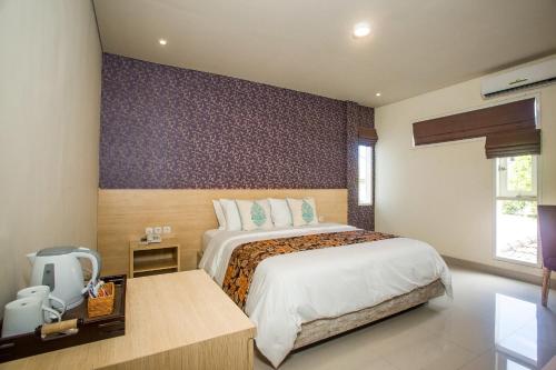 a bedroom with a large bed in a room at Mahalaksmi Boutique Hotel in Sanur