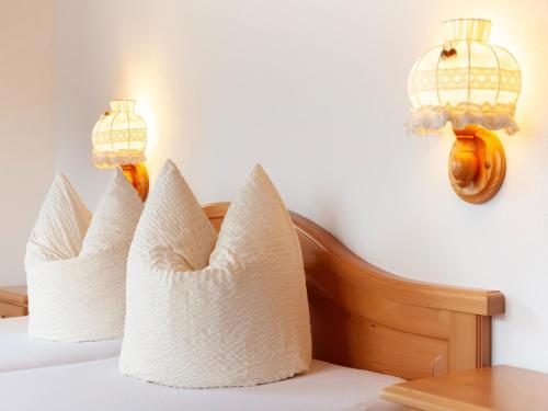 a bed with white pillows and a chandelier at Chalet in Zell am Ziller near Ski Lift in Gerlosberg