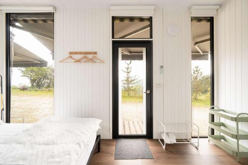 a bedroom with a bed and a large glass door at Forest View Cottage 1 by Tiny Away in Jiaoxi