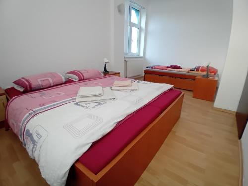 a bedroom with a large bed with pink and white sheets at U vodohospodárov in Banská Štiavnica
