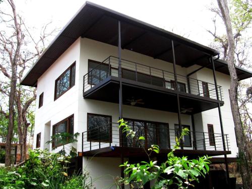 a white house with black balconies and trees at Gemini Villas , Gemini I in Contadora