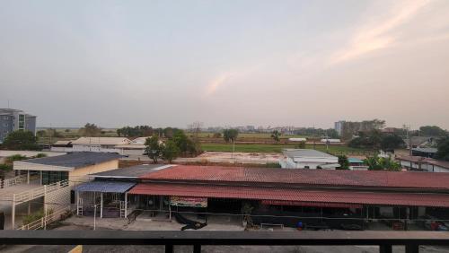 a building with a red roof in a city at หลังมอ บิวตี้ อพาร์ตเมนต์ in Ban Hua Khwai