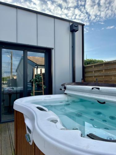 une baignoire jacuzzi sur le patio d'une maison dans l'établissement Love room proche du bassin , jacuzzi, jardin privé, à Marcheprime