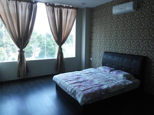 um quarto com uma cama em frente a uma janela em Vista Vacation Homestay em Malaca