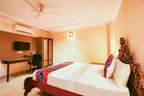 a bedroom with a bed and a desk in a room at FabHotel Maruthi Residency - Nr Lakdikapul Metro Station in Hyderabad