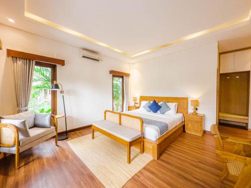 a bedroom with a bed and a chair and a couch at Ubud Shanti Rice Field House By Supala in Ubud