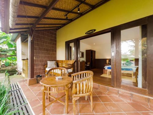 a patio with a table and chairs and a bedroom at Ubud Shanti Rice Field House By Supala in Ubud