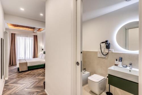 a bathroom with a sink and a toilet and a bed at Effe Luxury Rooms in Rome