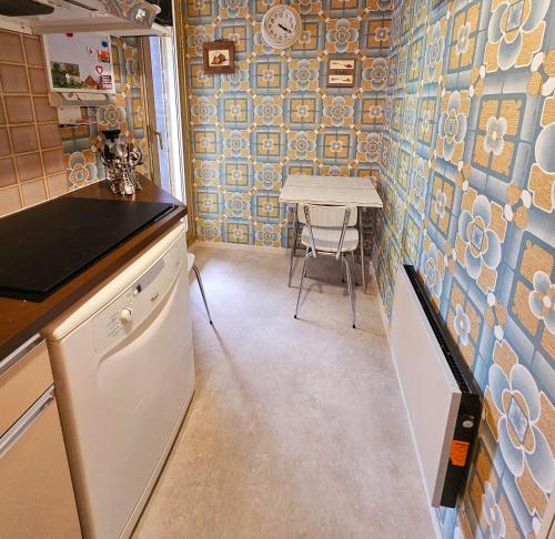 een keuken met een aanrecht en een tafel met een stoel bij Armorial studio cosy 100m plage in Deauville