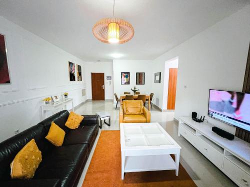 a living room with a black couch and a tv at Apartment D - 3 Bedrooms in Cope