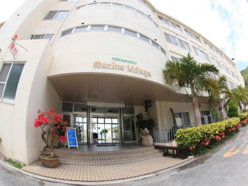 a building with a welcoming sign in front of it at Tokashiku Marine Villege in Tokashiki